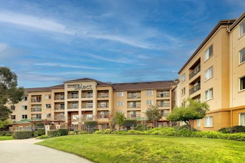 an apartment building with a lawn in front at Sonesta Select San Francisco Airport Oyster Point Waterfront in South San Francisco