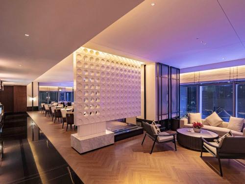 a living room with a bunch of tables and chairs at Grand Mercure Shenzhen Guangming in Shenzhen