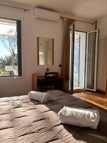 a bedroom with two beds and a desk and a window at Locanda Caffe Sport in Volpago del Montello