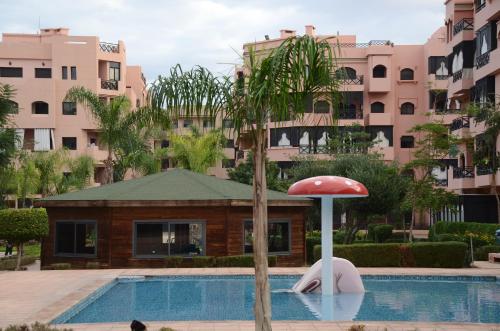 ein Pool mit einem Pilz vor einem Gebäude in der Unterkunft Paradise Marrakech in Marrakesch