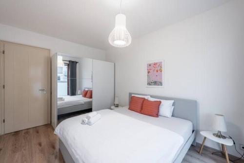プラハにあるリバー ダイヤモンド アパートメントのベッドルーム(オレンジ色の枕が付いた大きな白いベッド付)