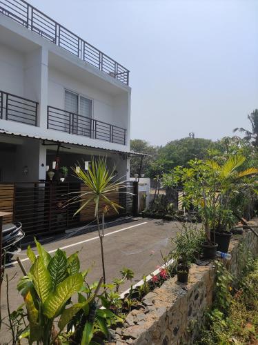 a white building with plants in front of it at The Beach House in Chennai