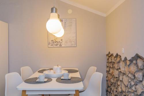 a dining room with a white table and a light at Apartments Lina in Vrh