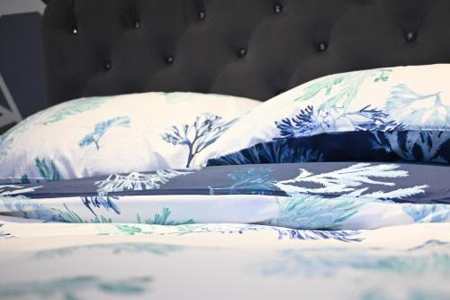 a bed with blue and white pillows on it at Urban Bliss 2BR Enfield Hideaway - Cosy Spot - Free Parking & Wi-Fi in Enfield