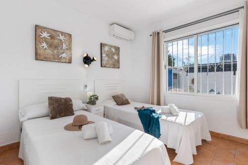 two beds in a room with a window at Villa Anais - PlusHolidays in Calpe
