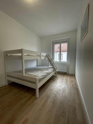 Cette chambre blanche comprend des lits superposés. dans l'établissement Mulhouse, Urban Family Nest, à Mulhouse