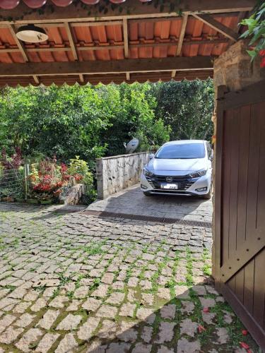 a car parked in a driveway next to a garage at Chalé charmoso e aconchegante em Visconde de Maua in Visconde De Maua