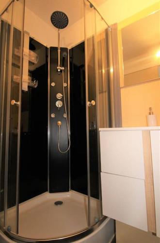 une douche avec une porte vitrée dans une salle de bain dans l'établissement PCOGASTO - Golfe de St-Tropez - Appartement dans résidence avec piscine avec vue sur marina, à Cogolin