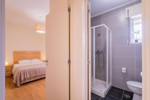 a bathroom with a shower and a bed in a room at 53 Urban Place in Ponta Delgada