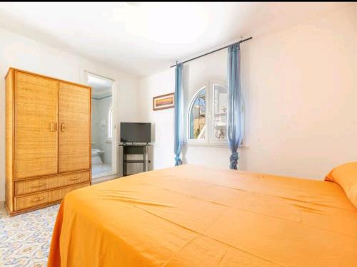 1 dormitorio con cama, ventana y TV en Coastal Charm A Home with a View in Santa Maria di Leuca, en Leuca