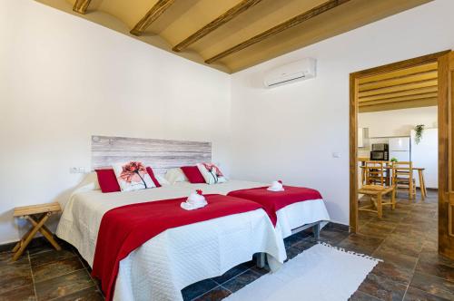 een slaapkamer met 2 bedden met rode en witte lakens bij Agroturismo El Limonar 2, YourHouse in Inca