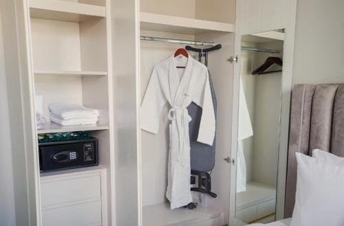 迪拜CitiHome-1BR in ZADA 5minutes to Business Bay Metro的衣柜配有白色长袍和镜子