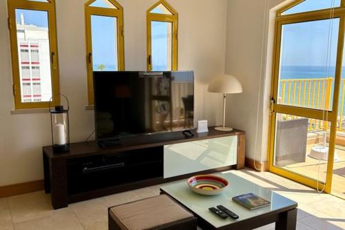 クアルテイラにあるTOM's House - T2 Sea Viewのテレビとテーブルのあるリビングルーム