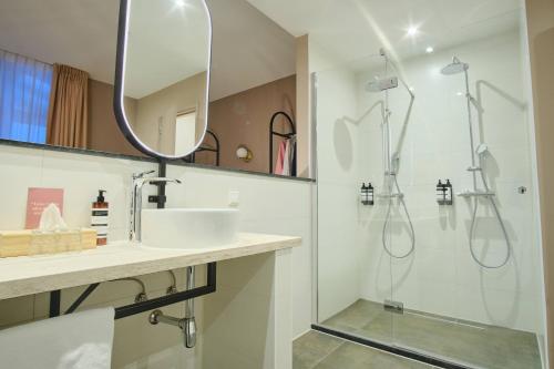 a bathroom with a sink and a shower at Hotel Halbert in Groningen