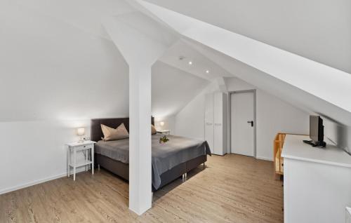 ein weißes Schlafzimmer mit einem Bett und einem TV in der Unterkunft Ferienwohnung Luke in Loxstedt