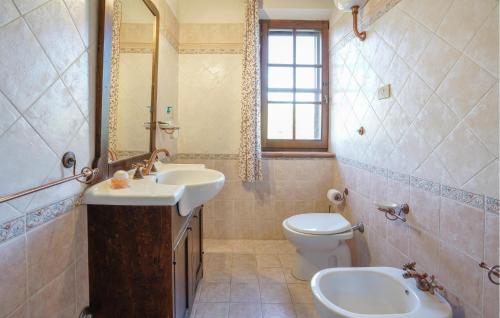 ein Badezimmer mit einem Waschbecken, einem WC und einem Spiegel in der Unterkunft Amazing Apartment In Sovana With House A Panoramic View in Sovana