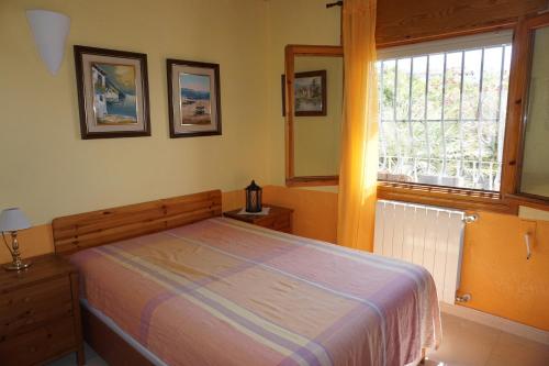 Schlafzimmer mit einem Bett und einem Fenster in der Unterkunft Los Limoneros in Pego