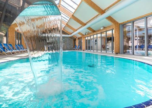 a swimming pool with a fountain in a building at Croft Country Park in Reynalton