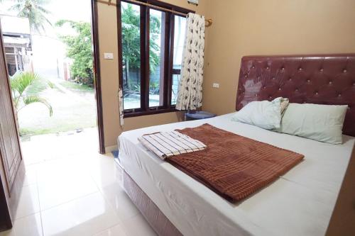 Un dormitorio con una cama con una manta. en Sapu Nyapah Losmen Syariah Tanjung Setia en Biha