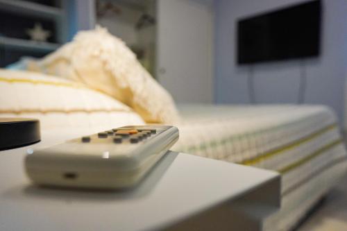 une télécommande posée sur une table à côté d'un lit dans l'établissement Pueblo Nuevo, à Junín