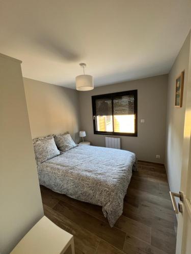 une chambre avec un lit et une fenêtre dans l'établissement Maison cosy à Lacanau, à Lacanau