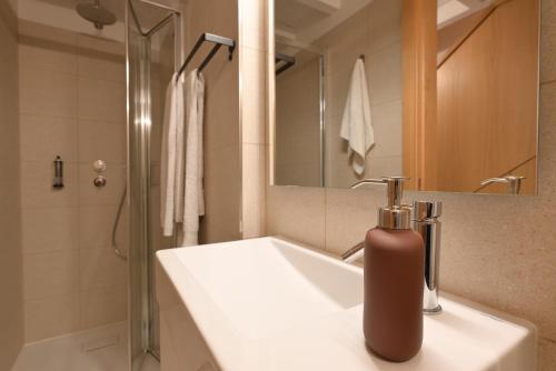 La salle de bains est pourvue d'un lavabo blanc et d'une douche. dans l'établissement In Barreta, à Barcelos