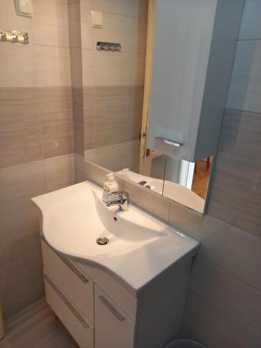a bathroom with a white sink and a mirror at Summer rooms Baška in Baška