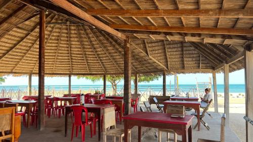 a restaurant on the beach with tables and chairs at El Viejo Moi Hospedaje & Restaurante in Cabo de la Vela