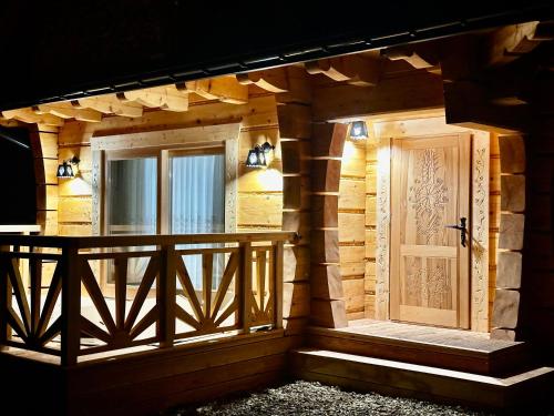 a front door of a house with a porch at Góralska Osada Tatra House z jacuzzi in Białka Tatrzanska