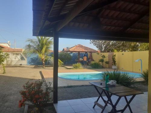 a patio with a table and a swimming pool at Casa para Carnaval coruripe c/ piscina perto da praia in Coruripe