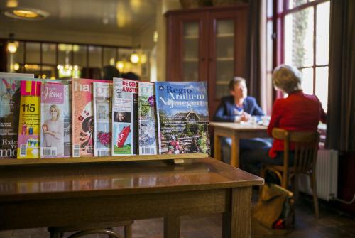 a table with books on it with people sitting at a table at Hotel Restaurant Oortjeshekken in Ooij