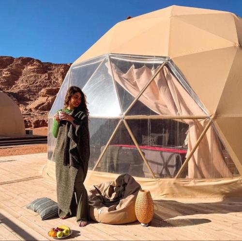 a woman standing in front of a tent at RUM EiLEEN LUXURY CAMP in Wadi Rum