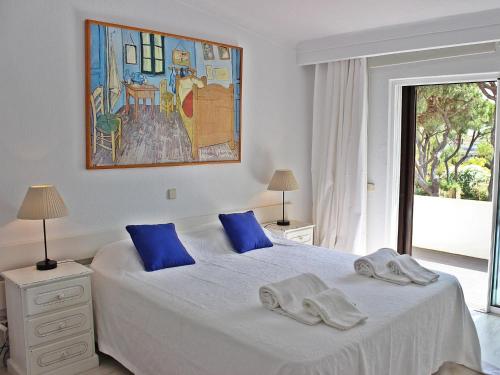 a bedroom with a bed with blue pillows on it at Villa Vale Garrão in Almancil