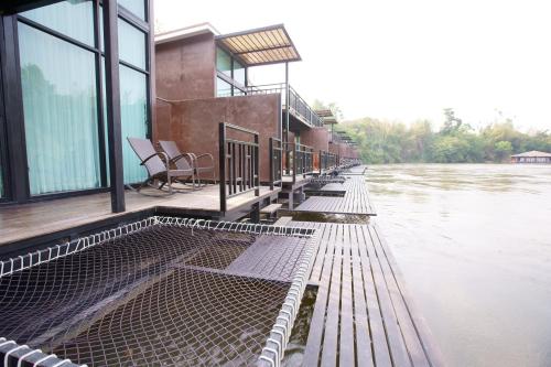 a building sitting on the side of a river at Kwai Tara Riverside Villas in Sai Yok