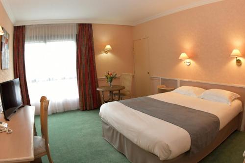 a hotel room with a bed and a television at Logis Lyon Est Porte de l'Ain in Saint-Maurice-de-Beynost