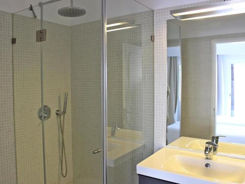 a bathroom with a shower with a sink and a glass shower door at Villa Vale Garrão in Almancil