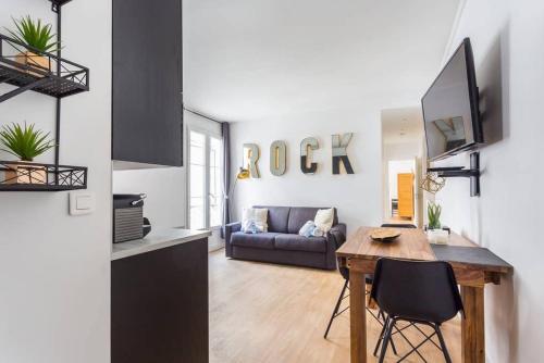 une cuisine et un salon avec une table et un canapé dans l'établissement Lemoine/Reaumur 1: Cosy Appartement 4P-1BR, à Paris