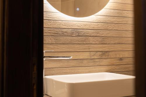 a bathroom with a white sink and a wall at Hotel Katafigio in Elati Trikalon