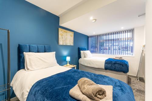 1 dormitorio con 2 camas y paredes azules en Stylish Free Parking Spacious Leisure Contractor en Walsgrave on Sowe