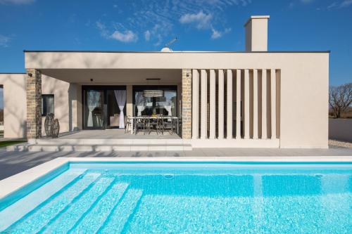 a swimming pool in front of a house at Villa Rose Nin ZadarVillas in Nin