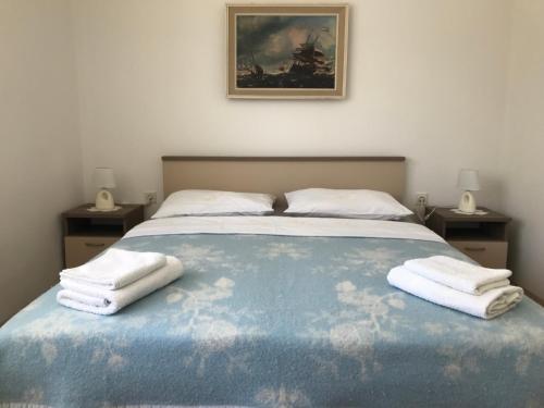 a bedroom with a bed with two towels on it at Summer rooms Baška 2 in Baška