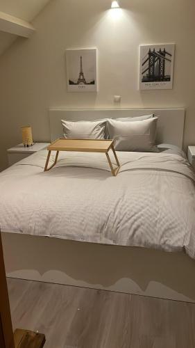 Una cama con una mesa de madera encima. en Voske1, en Gante
