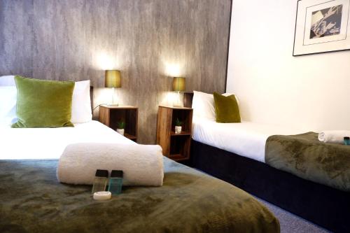um quarto de hotel com duas camas e uma cadeira em COSY 2 Bed APARTMENT NEARBY TRAIN STATION! em Watford