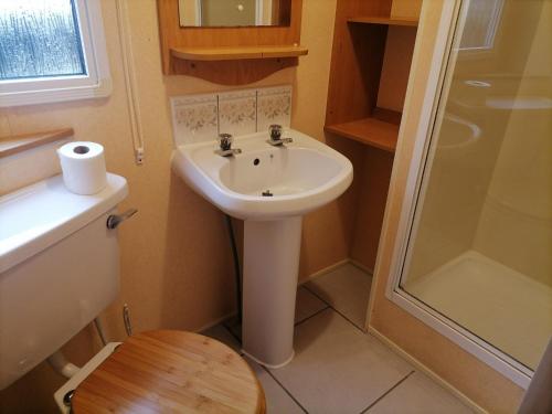 La salle de bains est pourvue d'un lavabo, d'une douche et de toilettes. dans l'établissement Beauport Holiday Park, à Hastings
