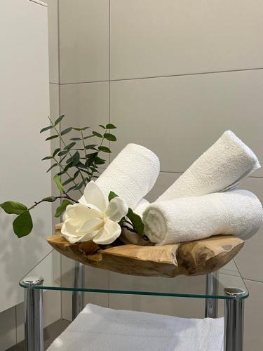 a basket with towels and flowers on a glass table at Ferienwohnungen am Markt - historischer Marktplatz im Herzen der Altstadt in Eschwege