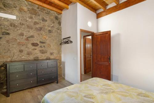 sypialnia z łóżkiem i kamienną ścianą w obiekcie Villa Paraiso Aldeano 1 w mieście San Nicolás