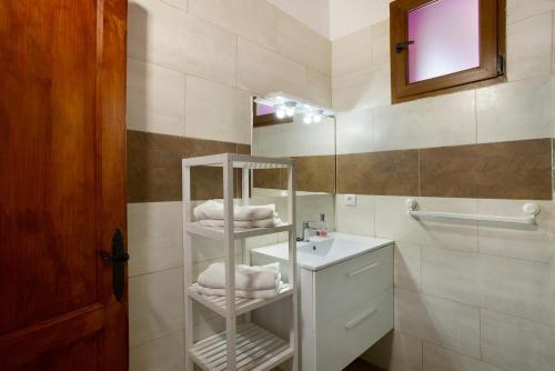 a bathroom with a sink and a shelf with towels at Villa Paraiso Aldeano 1 in San Nicolás