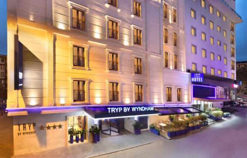 TRYP By Wyndham Istanbul Sisli Hotel في إسطنبول: فندق بتجربته لافتة نافذة أمامه