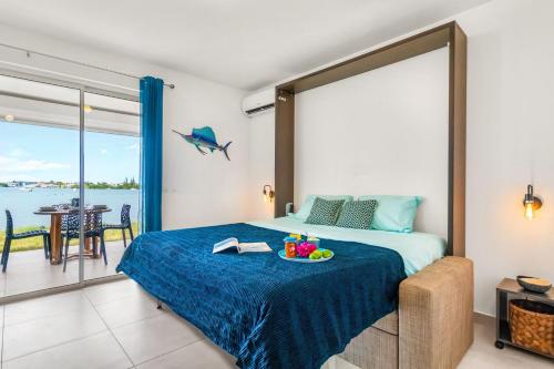 Un dormitorio con una cama con un bol de fruta. en Le Curaçao - Spacieux studio piscine vue Lagon en Marigot