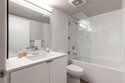 La salle de bains blanche est pourvue d'un lavabo, de toilettes et d'une baignoire. dans l'établissement Downtown 1br w gym pool nr Broad Museum LAX-286, à Los Angeles